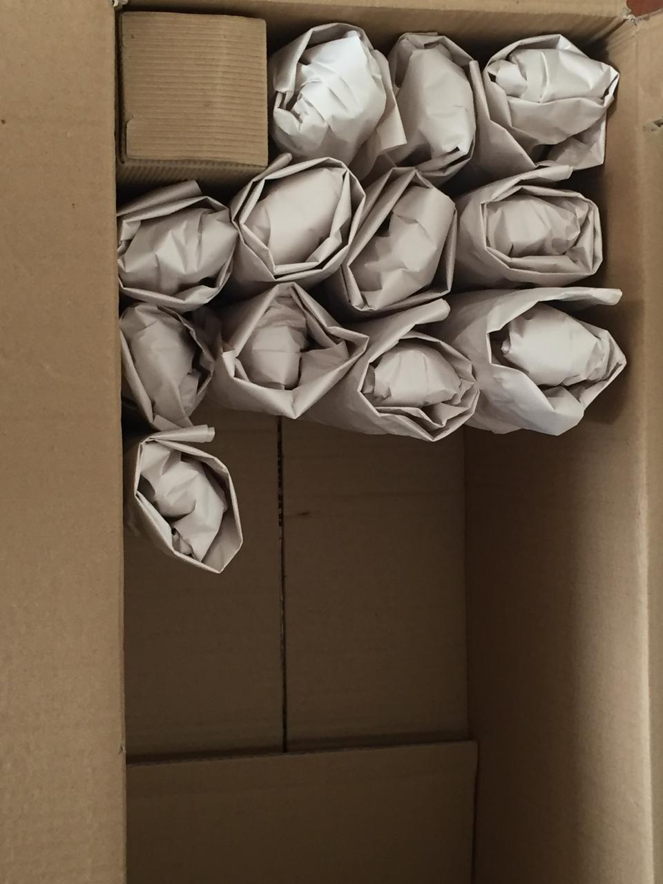 Objetos pequeños envueltos en papel dentro de una caja